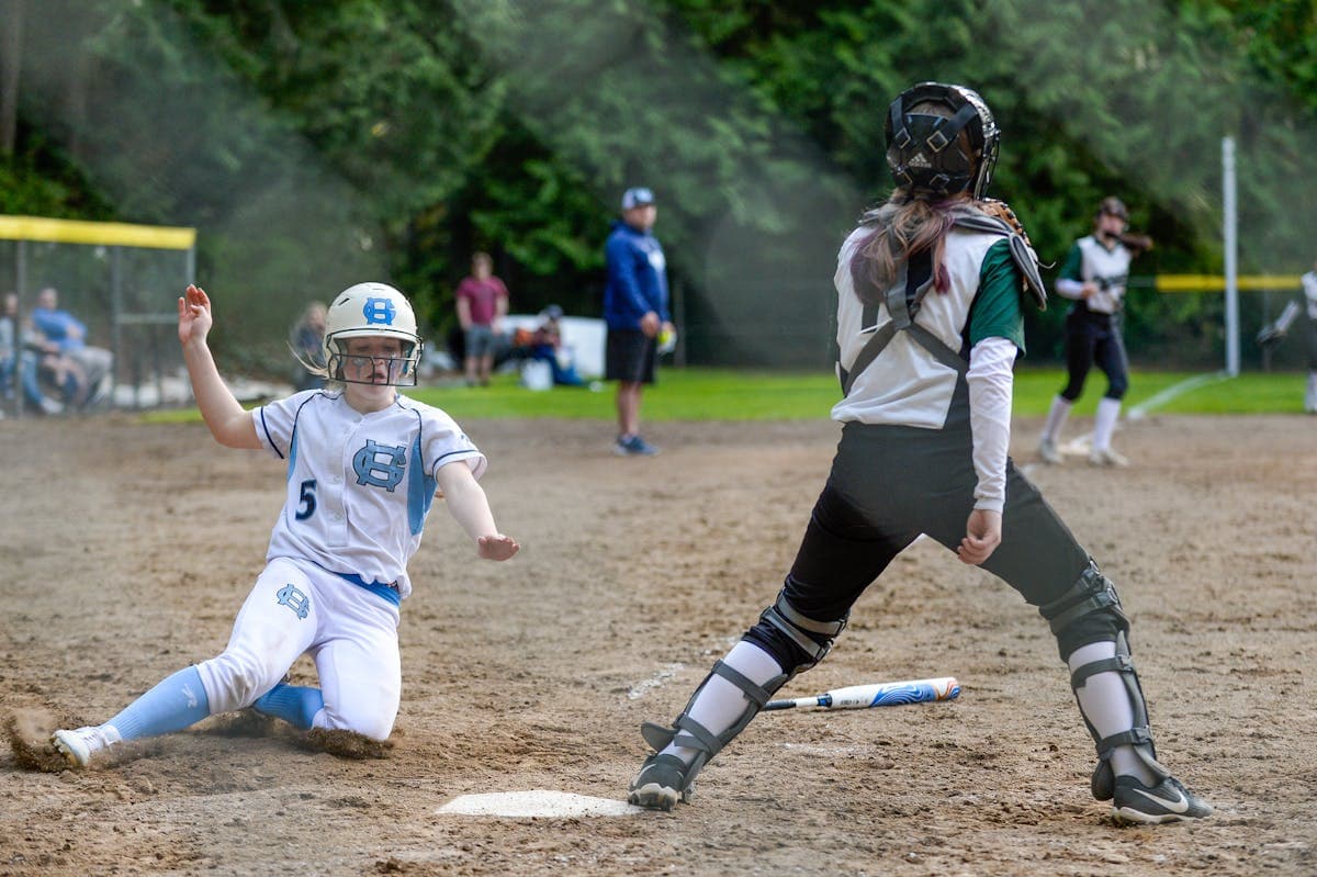 Softball player sliding into home plate